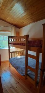 a bedroom with two bunk beds in a cabin at Casa do Loureiro in Arganil