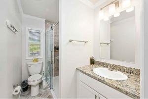 een witte badkamer met een toilet en een wastafel bij Sun Outdoors Chesapeake Bay in Temperanceville