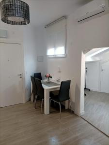 Habitación con mesa con sillas y ventana. en Apartamento Gran Vía Madrid W2, en Madrid