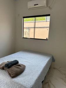 uma cama num quarto com uma janela em Casa Davisis - Parada Jalapão e Próximo Aeroporto em Palmas
