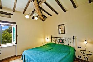 Un dormitorio con una cama verde y una ventana en Terra Di Michelangelo en Caprese Michelangelo