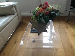 un vase de fleurs sur une table en verre dans le salon dans l'établissement Großzügige,98m2 grosse Wohnung in stadtnaher Traumlage, nur 200m zum Stadtpark, à Oldenbourg