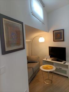 a living room with a couch and a table and a tv at Apartamento Gran Vía Madrid W2 in Madrid