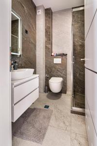 ein Bad mit einem WC, einem Waschbecken und einer Dusche in der Unterkunft Penthouse Apartment Bulevar Sarajevo in Sarajevo
