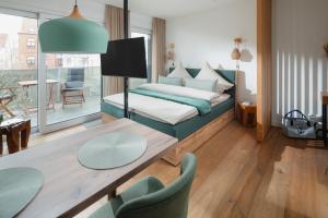 um quarto com uma cama, uma mesa e cadeiras em Haus Noena - Wohnung 7 Inselschatz em Norderney