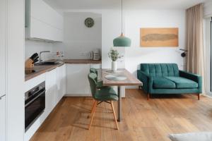 a kitchen with a table and a green chair at Haus Noena - Wohnung 7 Inselschatz in Norderney