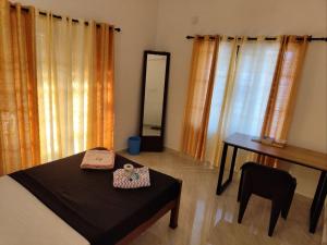 a bedroom with a bed and a table and a mirror at Paddy N Canal Homestay in Alleppey