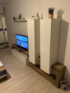 a white entertainment center with a tv in a living room at Aki Apartment in Zagreb