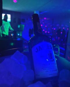 uma garrafa de vinho sentada numa sala escura em Day Off Club em Skopje