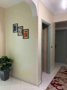 einen Flur mit Tür und ein paar Fotos an der Wand in der Unterkunft the best appartement in Taza
