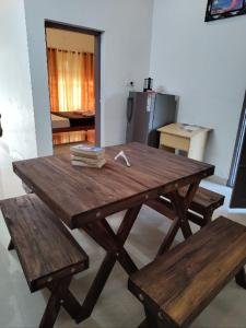 a wooden picnic table with two benches and a kitchen at Paddy N Canal Homestay in Alleppey