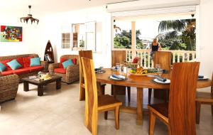 a living room with a wooden table and chairs at Villa Kanelle, F4, commerces et plage à 100m, in Le Diamant