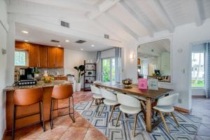 cocina y comedor con mesa de madera y sillas en Casa De Las Olas, en Fort Lauderdale