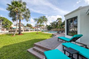 un patio con bancos azules y un patio en Casa De Las Olas, en Fort Lauderdale