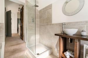 a bathroom with a sink and a glass shower at Bijou Cottage in Deal +18 photos
