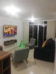a living room with two couches and a flat screen tv at Apartamento amoblado - Armenia Quindío. in Armenia