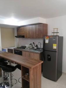 a kitchen with a stainless steel refrigerator and a table at Apartamento amoblado - Armenia Quindío. in Armenia