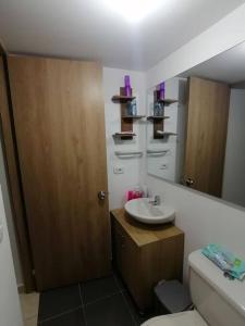a bathroom with a sink and a toilet and a mirror at Apartamento amoblado - Armenia Quindío. in Armenia