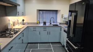 a kitchen with white cabinets and a sink and a stove at Barn near Colne for Leisure or Business in Colne