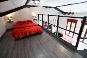 een slaapkamer met een rood bed op zolder bij Loft idéalement placé Mer, Aéroport, Centre Ville in Nice