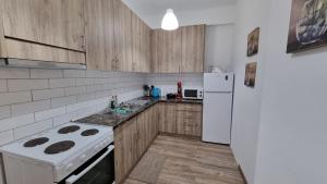 a kitchen with wooden cabinets and a white refrigerator at Luxury Apartment Serenity in Alexandroupoli