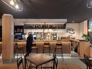 a man standing at a bar in a restaurant at Hotel Roquiño in Caldas de Reis