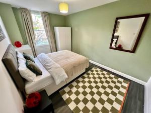 a bedroom with a bed and a mirror and a checkered floor at Affordable 2 bedroom flat Tower Bridge/Bermondsey in London