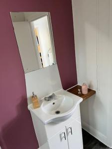 a bathroom with a white sink and a mirror at Affordable 2 bedroom flat Tower Bridge/Bermondsey in London