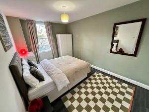 um quarto com uma cama e um piso em xadrez em Affordable 2 bedroom flat Tower Bridge/Bermondsey em Londres