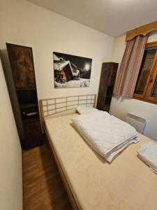 1 dormitorio con 1 cama grande con sábanas blancas en Les 3 Vallées - Hameau des eaux d'Orelle - Appartement 003, en Orelle