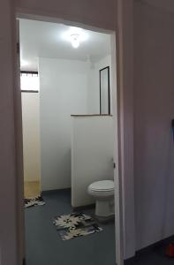 a bathroom with a toilet and a room with towels at Domus Herbace in San Isidro de El General