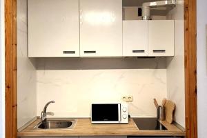 a kitchen with a sink and a microwave at Estudio Plaza Maribel con parking incluido in Sierra Nevada