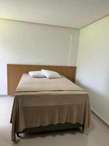 ein Bett mit zwei Kissen auf einem Zimmer in der Unterkunft Apartamento Tulum in Barra Grande