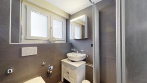 a bathroom with a white sink and a mirror at Le Belvedere By Alaïa in Crans-Montana +85 photos
