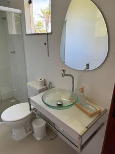 ein Badezimmer mit einem Waschbecken, einem WC und einem Spiegel in der Unterkunft Apartamento Tulum in Barra Grande