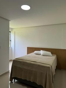 ein Schlafzimmer mit einem großen Bett mit einer weißen Wand in der Unterkunft Apartamento Tulum in Barra Grande