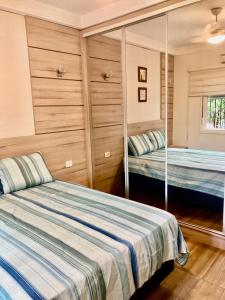 a bedroom with two beds and a mirror at Casa centro Falls in Foz do Iguaçu