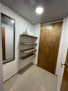 a room with a door and shelves and a mirror at Hotel Boutique San Joaquin Plaza in Medellín