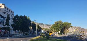 a city street with a yellow bus driving down the street at Marina Club Studio Apartment in Funchal