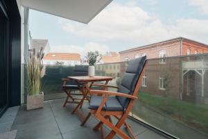 a balcony with a table and chairs and a window at Haus Noena - Wohnung 7 Inselschatz in Norderney