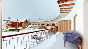 a balcony with snow on the roof of a building at Le Belvedere By Alaïa in Crans-Montana