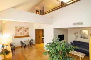 a living room with a blue couch and a plant at Hotel Villa Odon in Villaviciosa de Odón