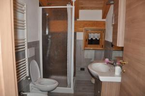 La petite salle de bains est pourvue de toilettes et d'un lavabo. dans l'établissement Le Foyer de la Ferme, à Aoste