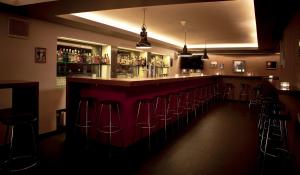 a bar with a row of bar stools at Arena Lodge in Flims