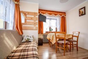 a bedroom with a bed and a table and chairs at U Capka in Poronin