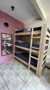 um quarto com beliches e um espelho em Fica, Vai ter Bolo Hostel em Itajaí