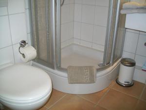 ein Badezimmer mit Dusche neben einer Toilette und einem Waschbecken in der Unterkunft Strandappartement in Westerland