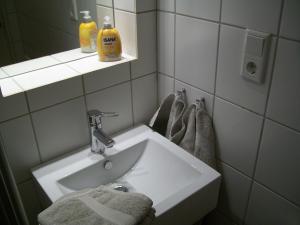 ein Badezimmer mit Waschbecken, Spiegel und Handtüchern in der Unterkunft Strandappartement in Westerland