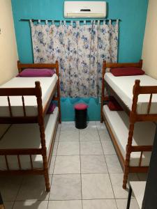 two bunk beds in a room with a window at Fica, Vai ter Bolo Hostel in Itajaí