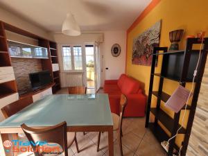 salon ze stołem i czerwoną kanapą w obiekcie Travel Solution - SeaView & Roman Apartments CIR 13014 w Anzio